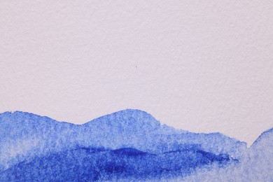 Abstract blue watercolor painting on white paper, top view. Space for text