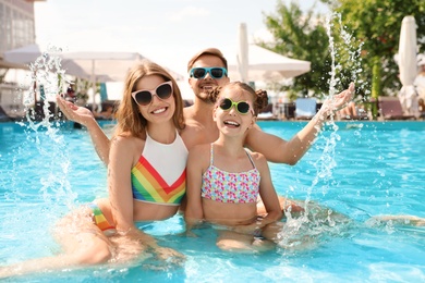 Photo of Happy family in pool on sunny day