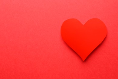 Photo of One paper heart on red background, top view. Space for text