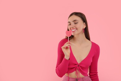 Photo of Pink look. Beautiful woman with lollipop on color background, space for text