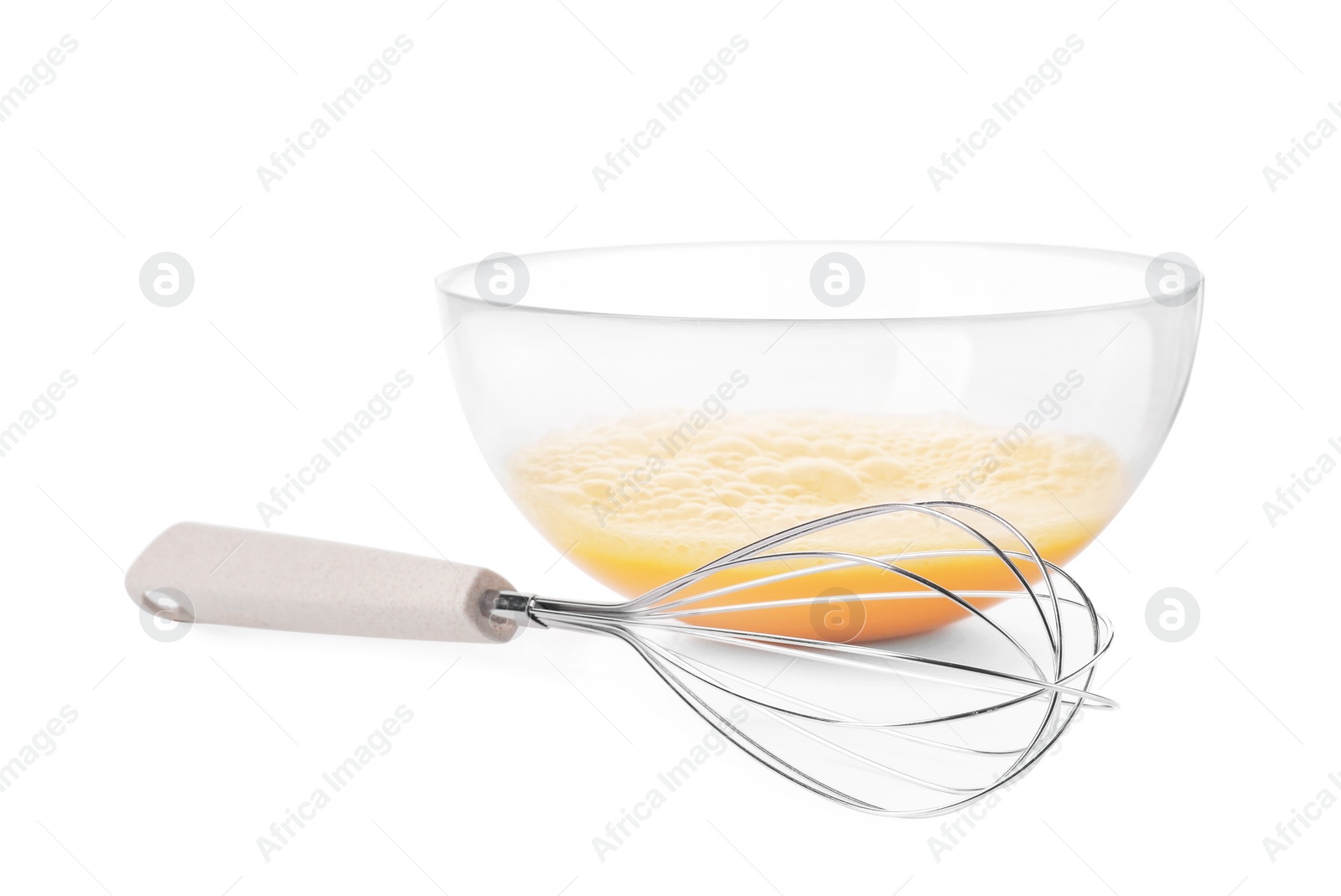 Photo of Beaten eggs in glass bowl and whisk isolated on white