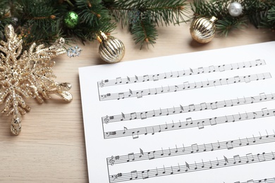 Photo of Composition with Christmas music sheets on wooden background, closeup