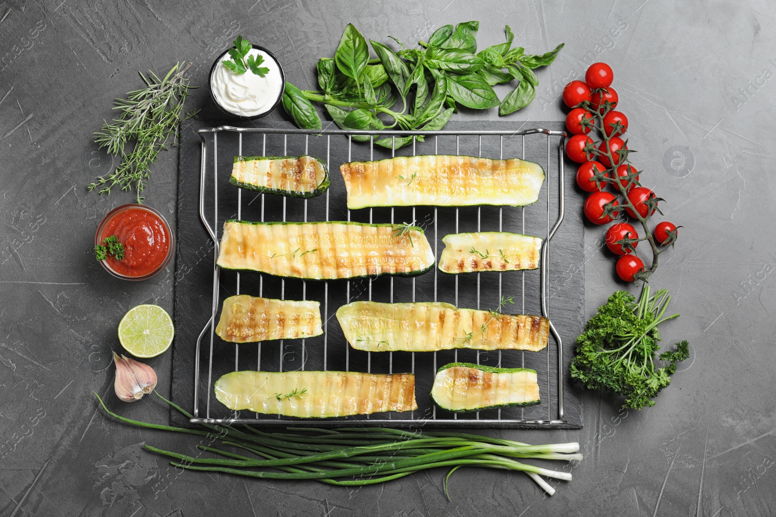 Photo of Flat lay composition with delicious grilled zucchini slices on grey table