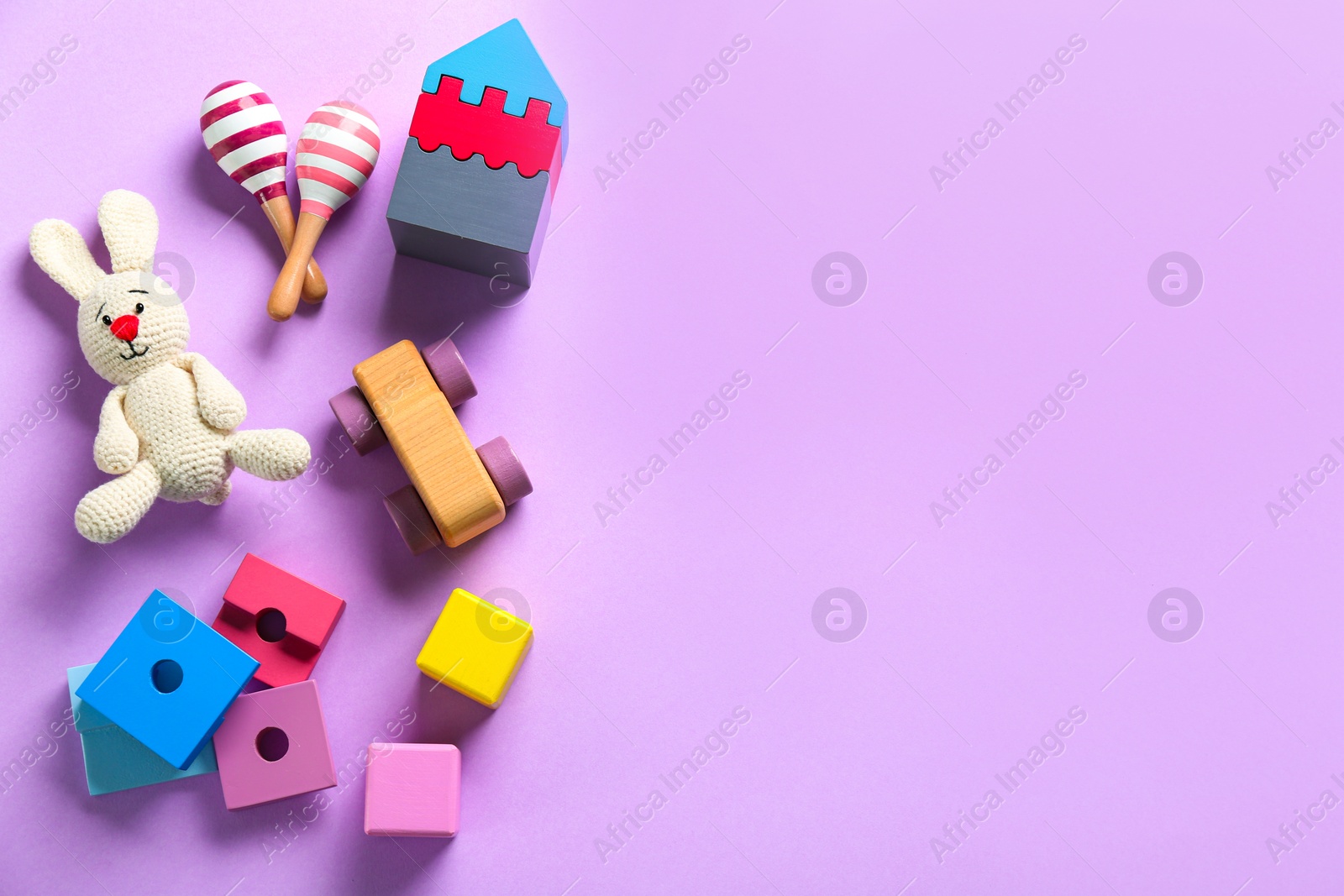 Photo of Different toys on lilac background, flat lay. Space for text