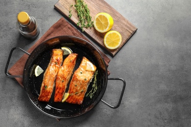 Dish with tasty cooked salmon on table, top view