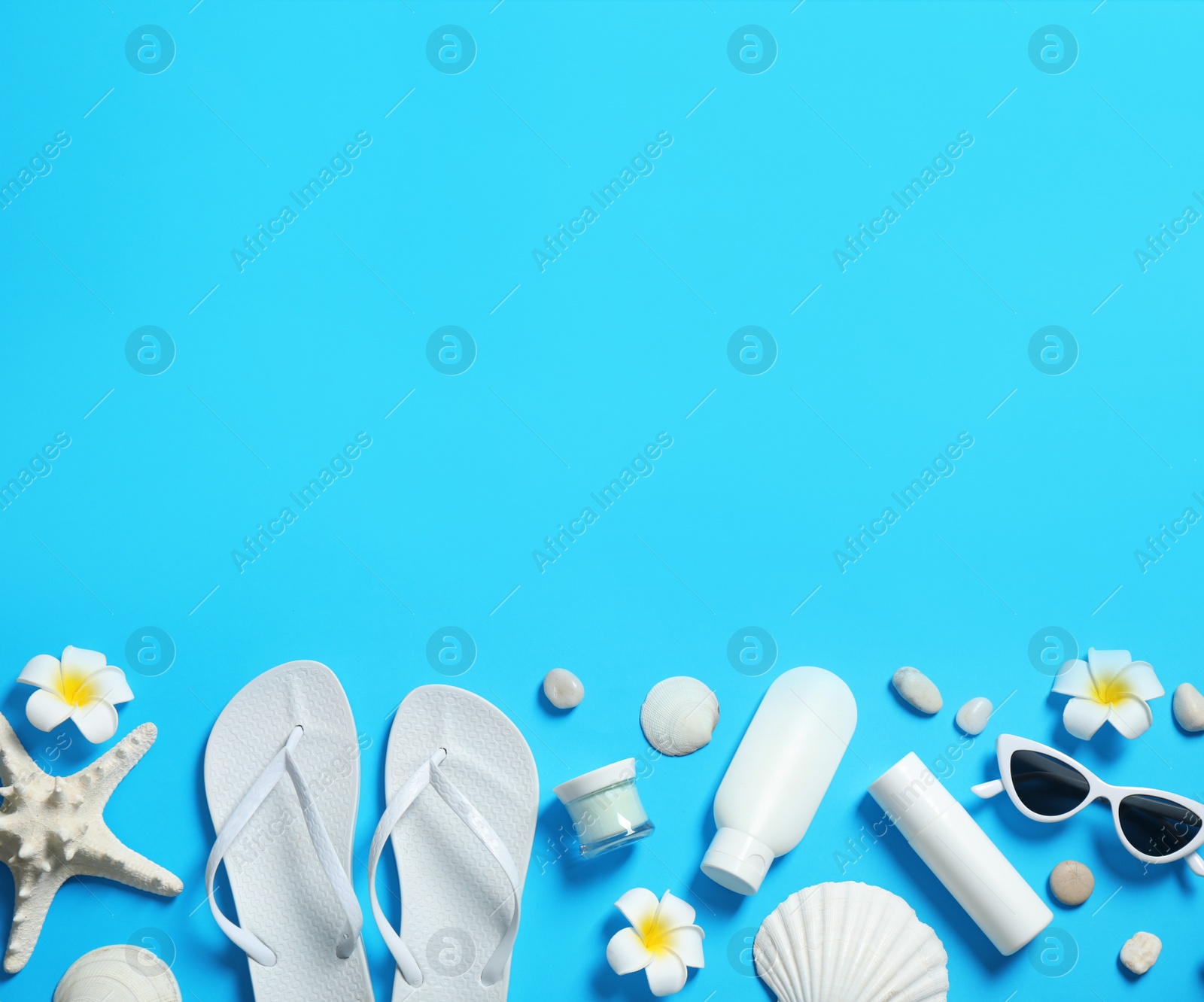 Photo of Flat lay composition with stylish beach accessories on light blue background, space for text