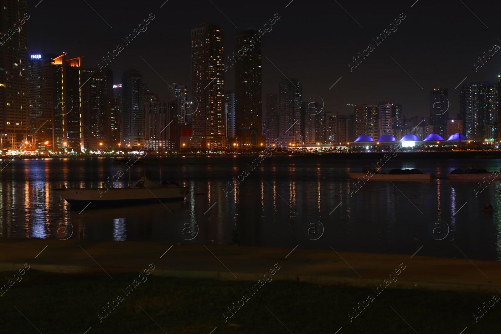 Photo of DUBAI, UNITED ARAB EMIRATES - NOVEMBER 04, 2018: Night cityscape with illuminated buildings near water canal