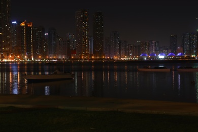 Photo of DUBAI, UNITED ARAB EMIRATES - NOVEMBER 04, 2018: Night cityscape with illuminated buildings near water canal