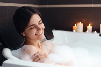 Photo of Happy beautiful woman taking bubble bath. Romantic atmosphere