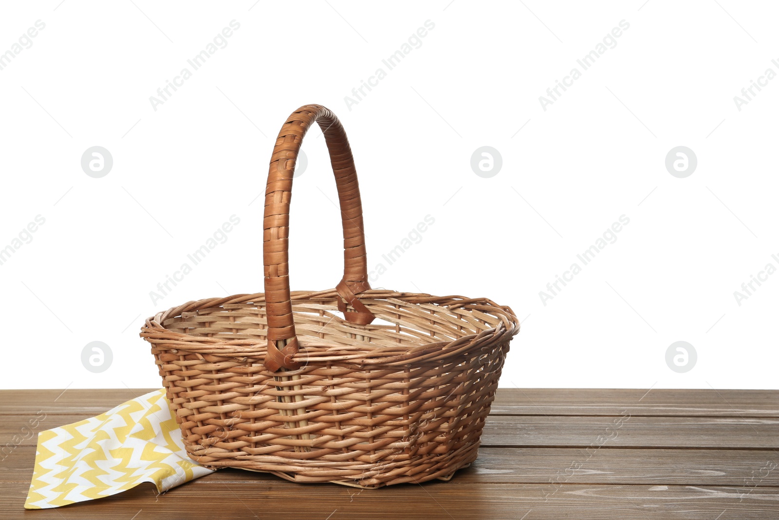 Photo of Empty wicker basket and cloth on wooden table against white background, space for text. Easter holiday