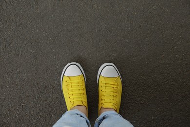 Woman standing on asphalt, top view. Space for text