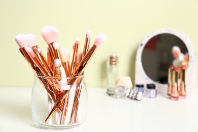 Set of makeup products and brushes on table. Space for text