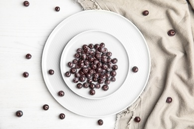 Photo of Plates with fresh acai berries on wooden table, top view