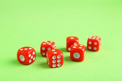 Photo of Many red game dices on green background, closeup