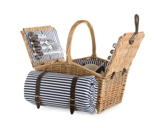 Photo of Wicker basket with picnic essentials and blanket on white background