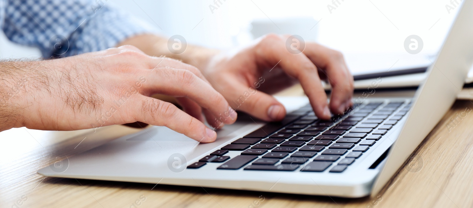 Image of Young man working on computer at table indoors, closeup. Banner design