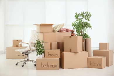 Photo of Pile of moving boxes in empty room