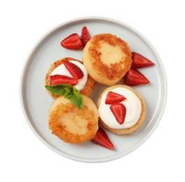 Delicious cottage cheese pancakes with strawberries, honey and sour cream on white background, top view