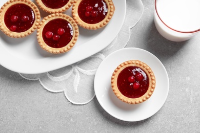 Photo of Tasty tartlets with jam on grey background, top view