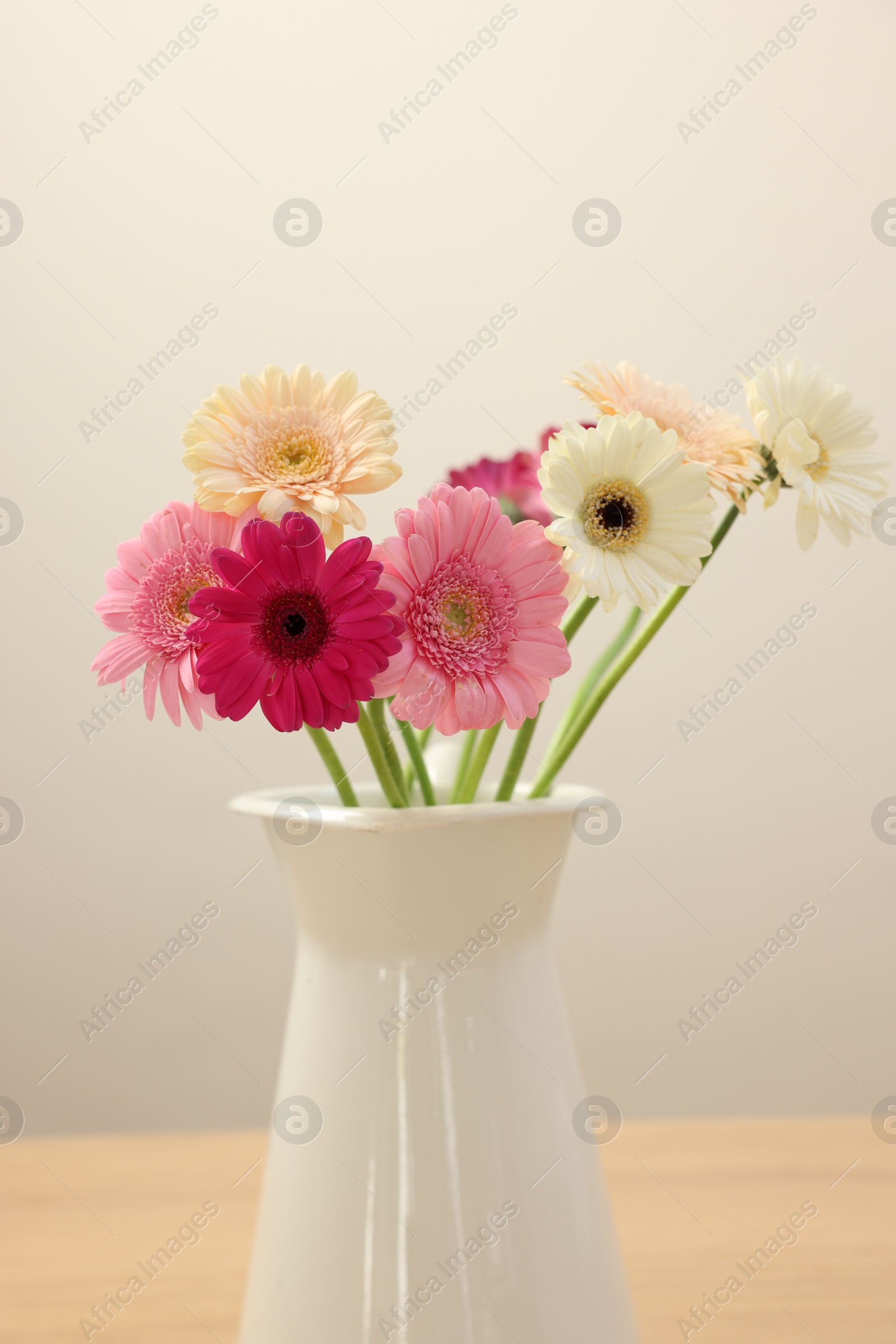 Photo of Vase with beautiful gerbera flowers on wooden table