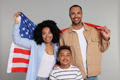 Photo of 4th of July - Independence Day of USA. Happy family with American flag on light grey background