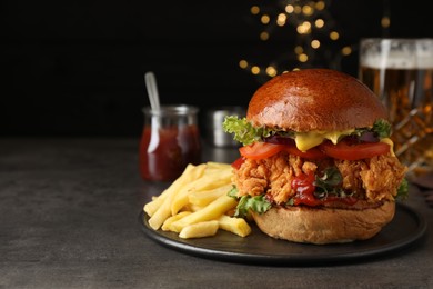 Photo of Delicious burger with crispy chicken patty and french fries on black table. Space for text