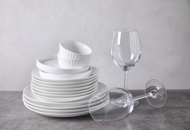 Photo of Set of clean dishware on grey table