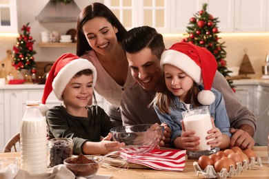 Photo of Happy family with ingredients for delicious Christmas cookies at home