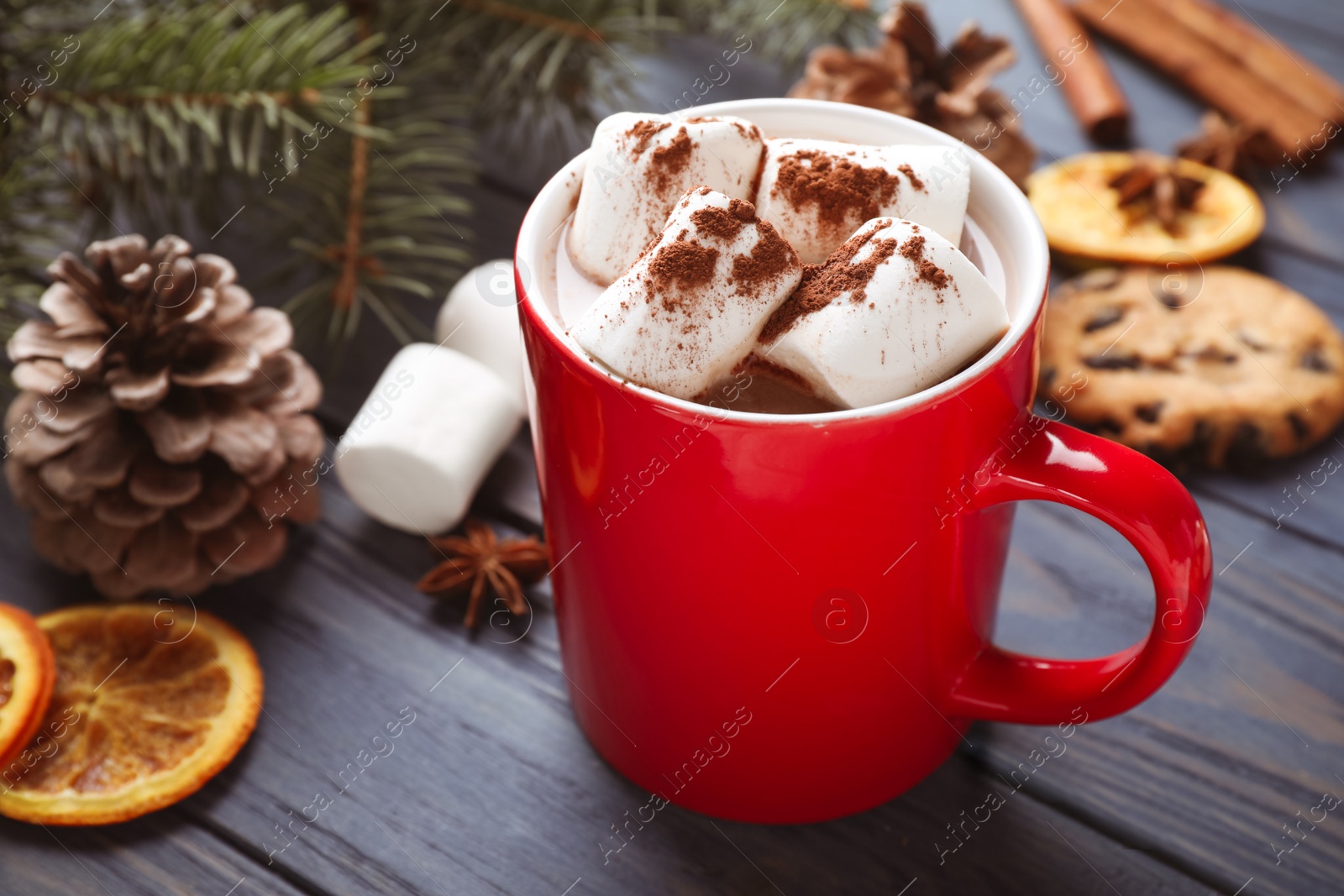 Photo of Composition of tasty cocoa with marshmallows in cup on blue wooden table