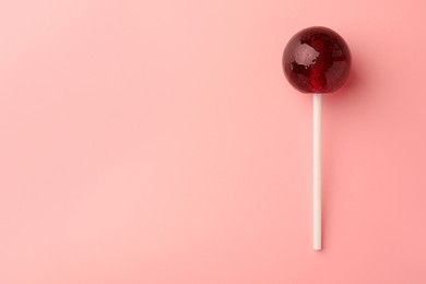 Tasty lollipop on pink background, top view. Space for text