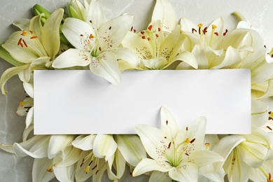 Photo of Beautiful lily flowers and blank card, top view