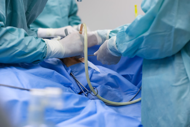 Photo of Professional doctors performing 
frontal sinus trephination in surgery room, closeup