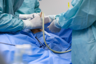 Professional doctors performing 
frontal sinus trephination in surgery room, closeup