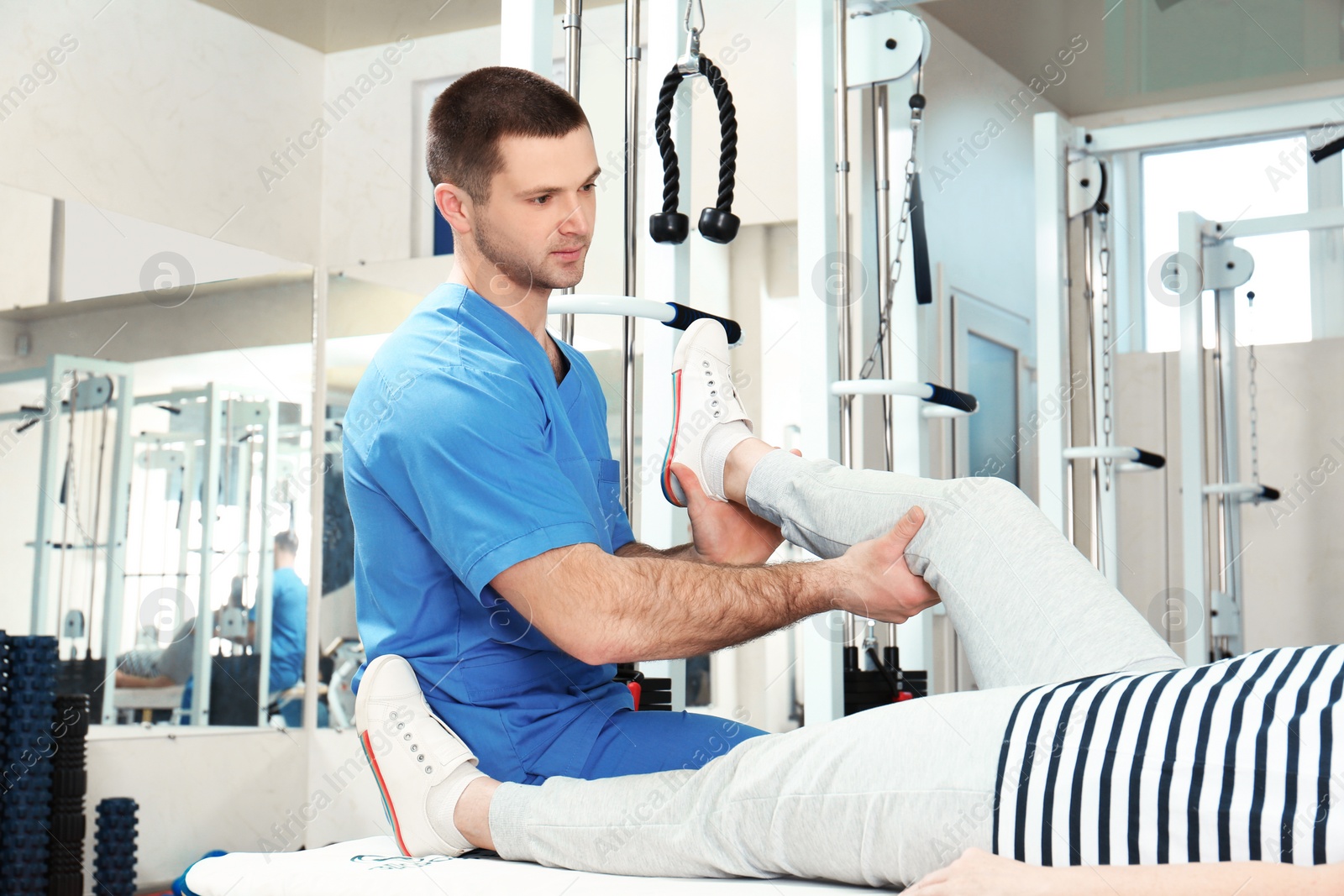 Photo of Physiotherapist working with patient in rehabilitation center