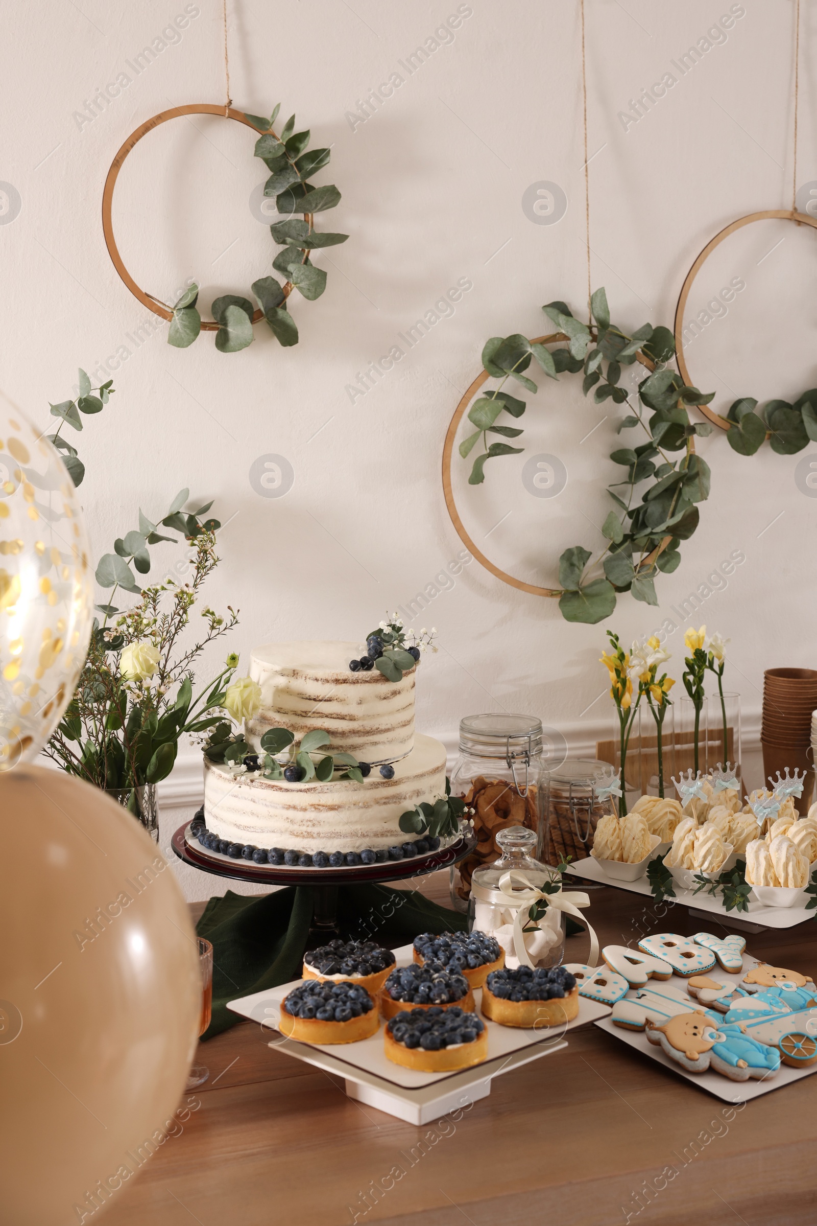 Photo of Beautiful cake and other treats on table in room. Baby shower party