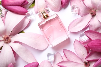 Photo of Beautiful pink magnolia flowers, bottle of perfume and ice cubes on white background, flat lay