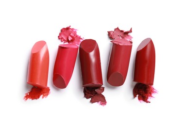 Different bright lipsticks on white background, top view