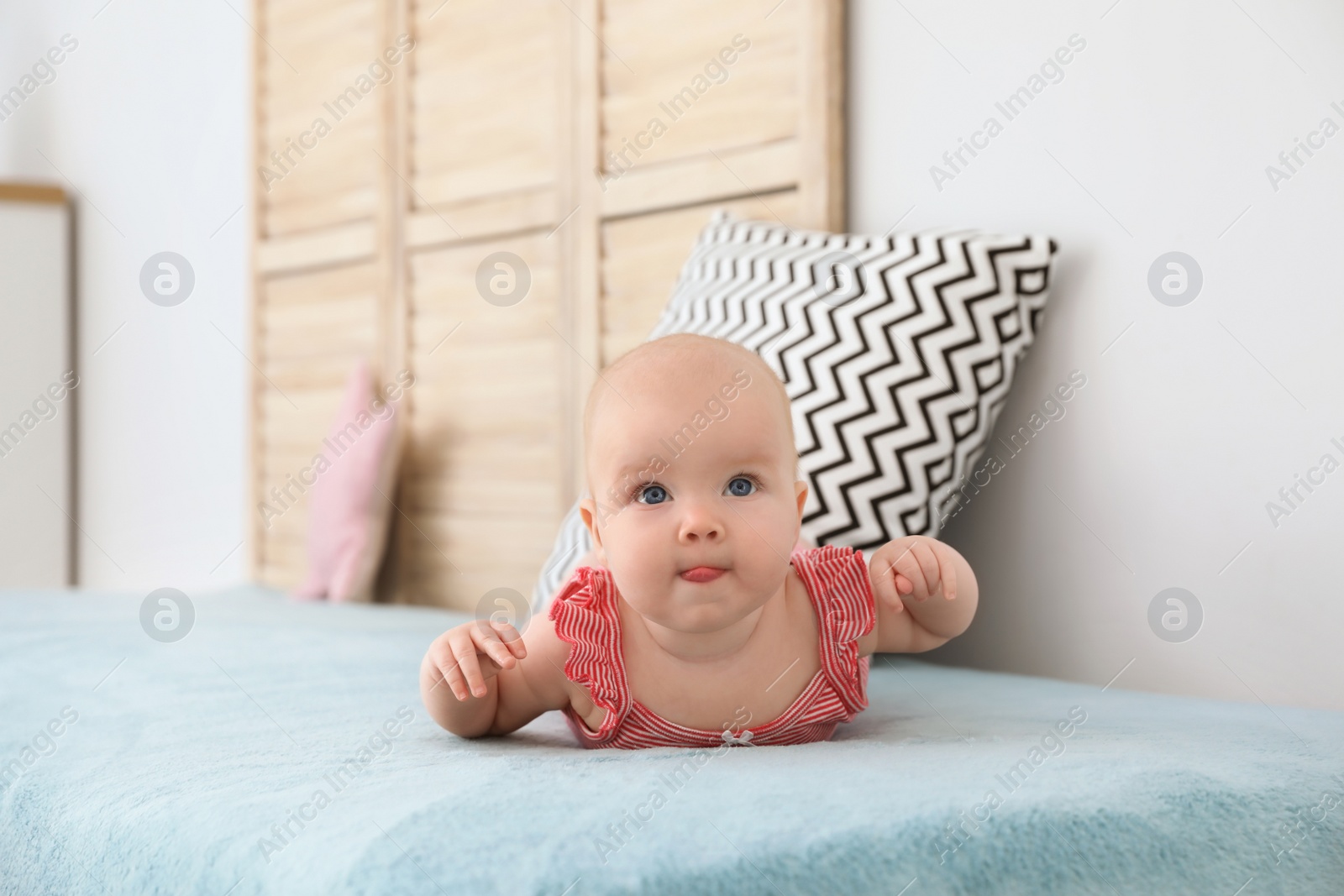 Photo of Cute little baby lying on bed at home