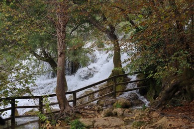 Picturesque view of beautiful waterfall and rocks outdoors