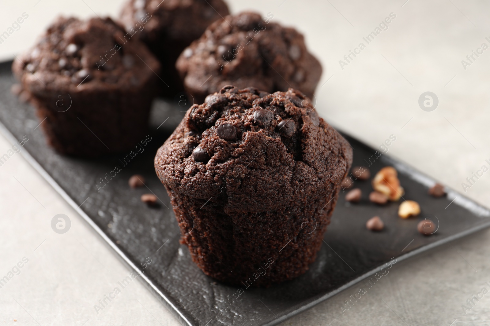 Photo of Delicious chocolate muffins on light table, closeup