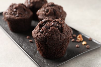 Delicious chocolate muffins on light table, closeup