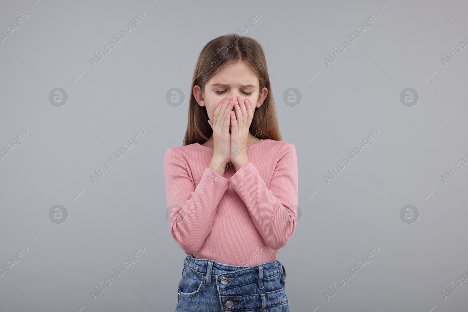 Photo of Sick girl coughing on gray background. Cold symptoms