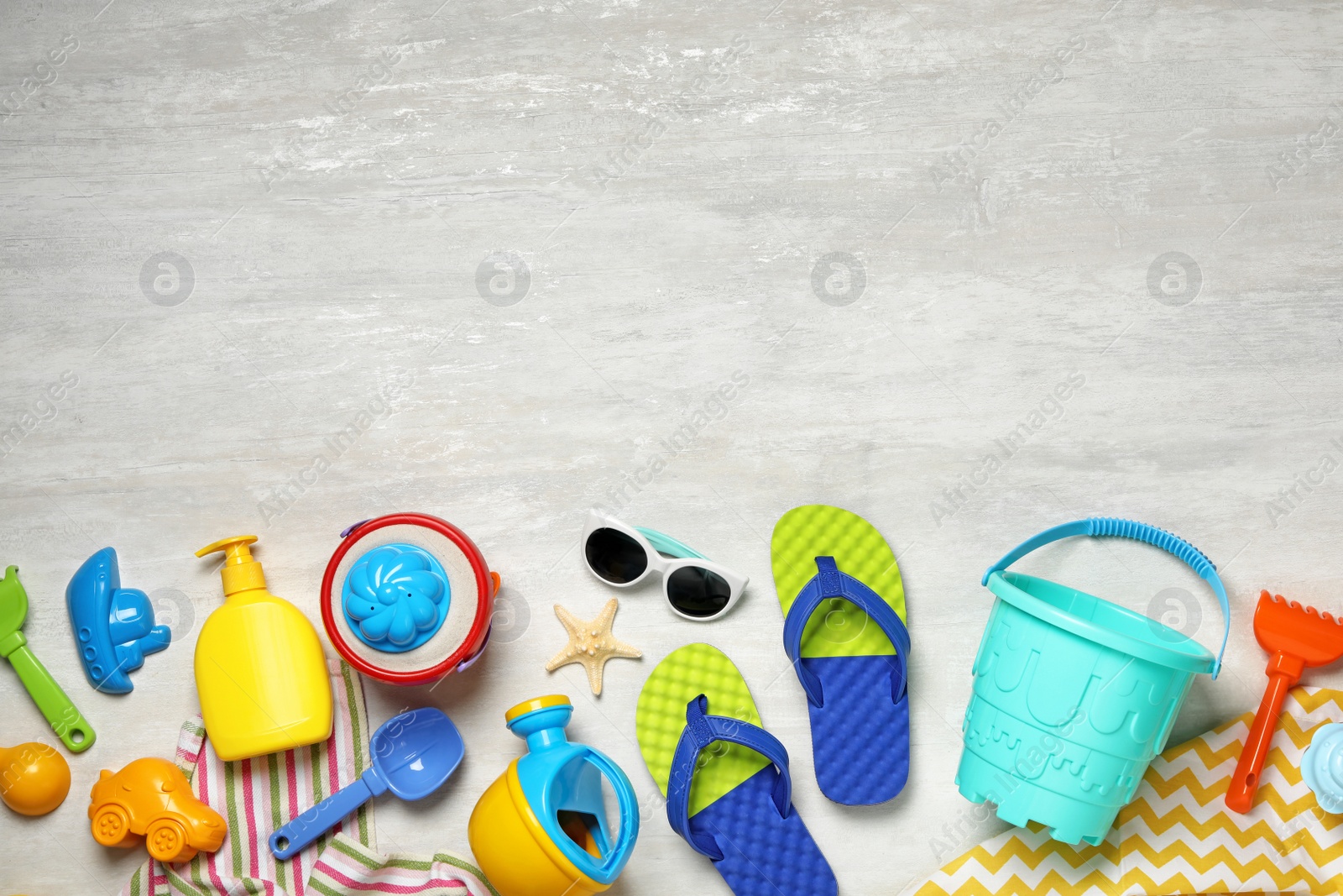 Photo of Flat lay composition with beach toys on light background. Space for text