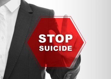 Image of Woman touching warning sign with phrase Stop Suicide on white background, closeup. Black and white photo with red color accent