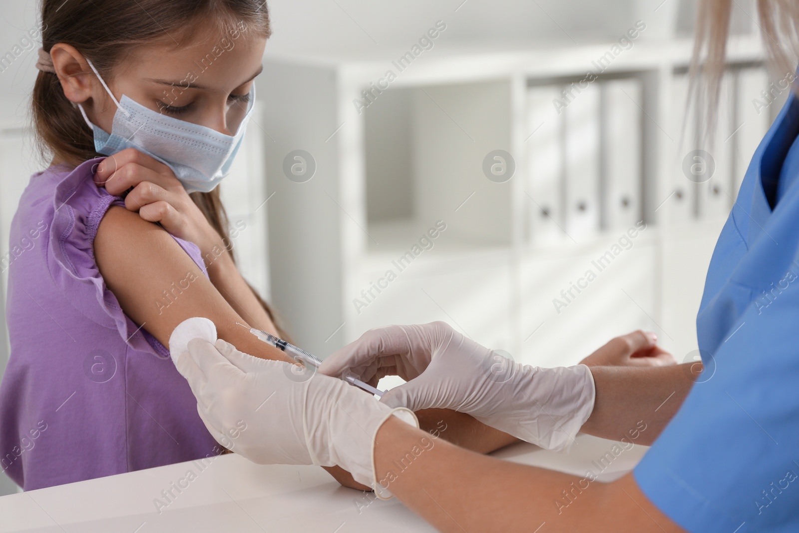 Photo of Doctor vaccinating little girl in hospital. Health care