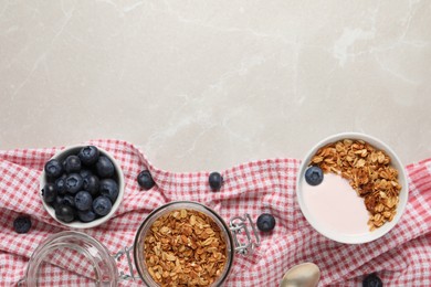Photo of Bowl of yogurt with granola and blueberries on grey marble table, flat lay. Space for text