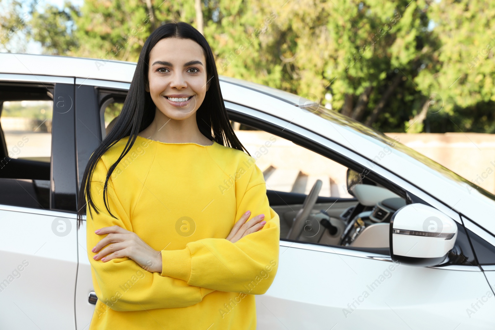 Photo of Beautiful young driver near modern car on city street