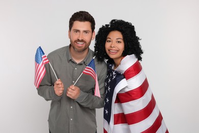 Photo of 4th of July - Independence Day of USA. Happy couple with American flags on white background