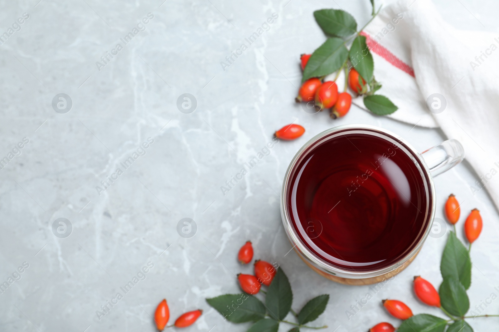 Photo of Flat lay composition with aromatic rose hip tea on light grey marble table. Space for text