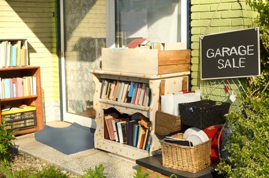 Photo of Many books and some other stuff near house. Yard sale